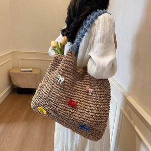 Straw woven tote bag with colorful knitted bows and blue plush shoulder strap
