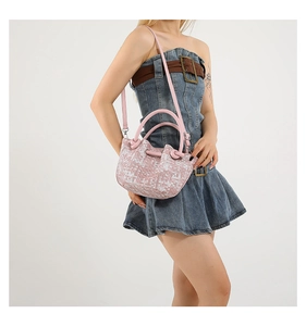 Detail of pink and white checkered woven bucket bag with top handle and strap