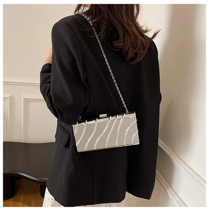 Pochette da sera argento rettangolare con trama ondulata e tracolla a catena su modella
