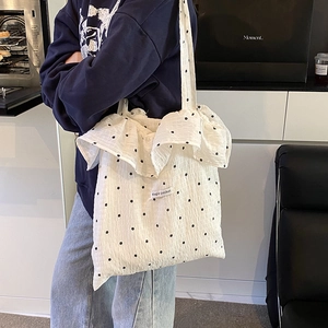 White floral tote bag with ruffled edges and Magic Pocket label carried by a model