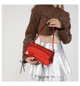 Glossy red patent leather baguette bag with shoulder strap shown on a model
