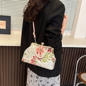 Vintage embroidery crossbody bag with floral patterns and pearl handle shown on model