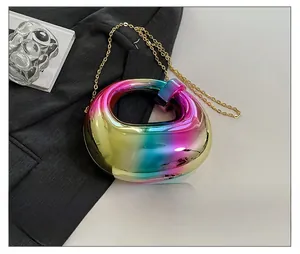 Macro detail of round rainbow acrylic evening bag with metallic chain and mirror finish
