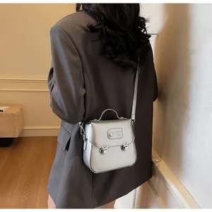 Détail du sac bandoulière en cuir métallisé argenté avec doubles boucles et logo