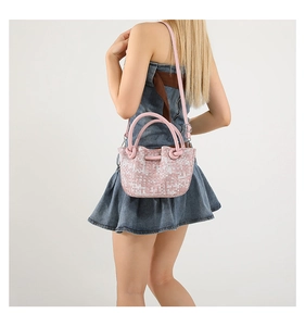 Detailed shot of pink woven tweed handbag with leather handle and adjustable shoulder strap