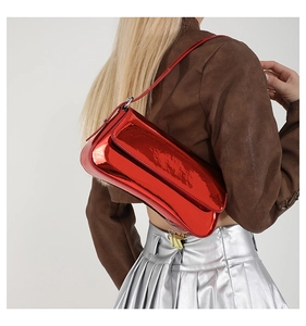 Detailed side view of a glossy red patent leather underarm bag on a fashion model