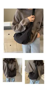 Detailed view of black crescent crossbody bag with adjustable wide strap and woven zip pull