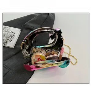 Detail showing internal capacity of rainbow acrylic clutch bag with golden chain strap