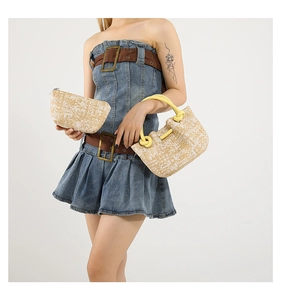 Detail of woven beige tote bag with bright yellow handles and matching clutch pouch set