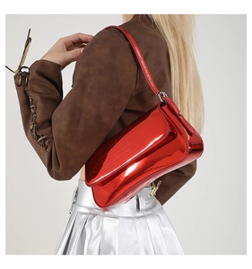 Glossy red patent leather shoulder bag styled with metallic silver pleated skirt