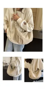 Detailed view of beige canvas dumpling bag with textured woven rope zipper pull