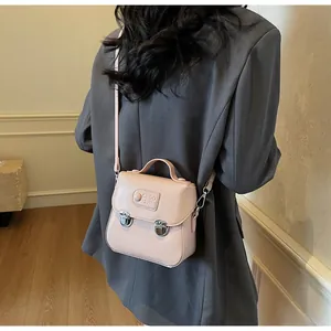 Détail du mini sac bandoulière rose avec deux fermoirs argentés et gaufrage élégant