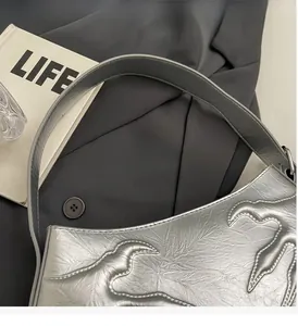 Detailed macro view of silver handbag with flame-textured leather and sturdy flat handle