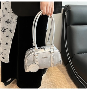 Detail of silver metallic Boston bag with premium leather handles and brand logo