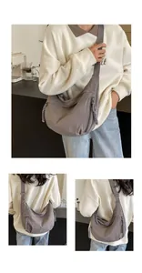 Macro detail of the grey crescent crossbody bag showing zippers and durable fabric texture
