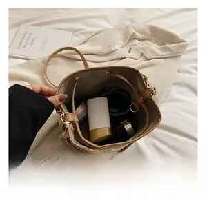 Detail showing internal capacity of woven bucket bag with cosmetic items and leather trim
