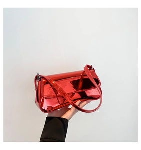 Detail of red patent leather shoulder bag with glossy metallic finish and sleek strap