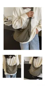Detail of dark green crescent bag featuring durable canvas fabric and woven zipper pull