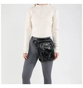 Detail of black steampunk leg bag featuring silver skull emblem and textured PU leather