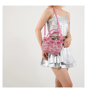 Close-up of pink woven mini bucket bag with resin handles and detachable shoulder strap