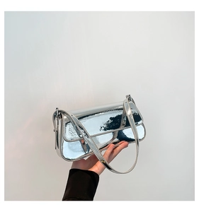Detail of silver patent leather shoulder bag with glossy mirror finish and stitching