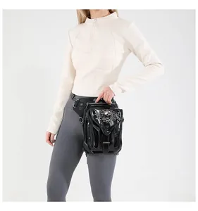 Detail of steampunk thigh bag in black patent leather with silver skull and gothic metal hardware