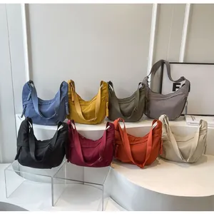 Detailed display of crescent crossbody bags in eight colors with wide straps and woven zippers