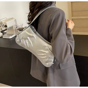 Detailed view of silver baguette bag with flame embossed texture on shoulder strap
