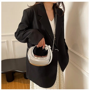 Silver metallic crescent handbag styled with black blazer and polka dot skirt outfit