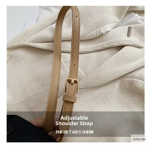 Close-up of adjustable beige leather strap with a polished gold buckle on a woven bag