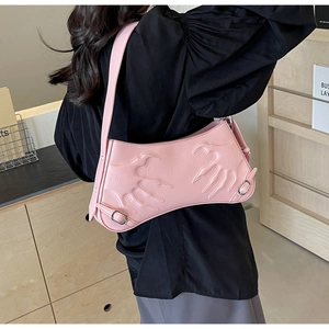 Detail of pink French baguette bag with embossed flame pattern and silver buckles