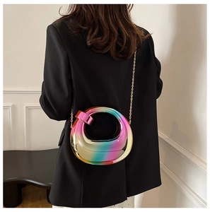 Detail of creative rainbow gradient ring bag with gold chain strap on black blazer