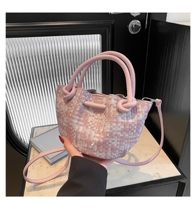 Detail of pink and white woven bucket bag showing knot texture and round handle