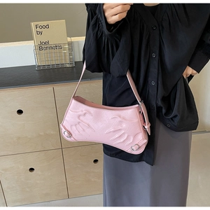 Detail of pink baguette bag featuring unique palm embossed texture and silver hardware