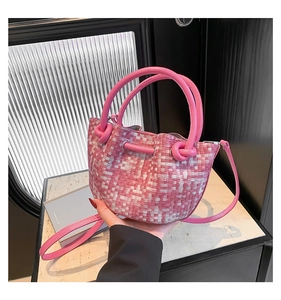 Detail of pink and white woven basket bag with round leather handle and strap
