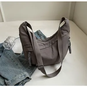Detail shot of textured dark hobo bag with wide strap and woven zipper puller