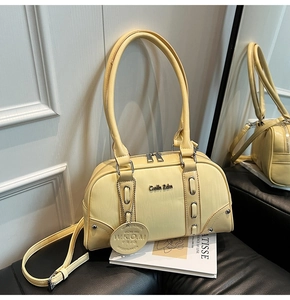 Macro detail of cream yellow Boston bag showing leather texture and silver metal zipper