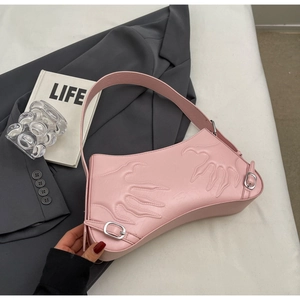Detail of pink baguette bag with claw relief design and silver metal buckle accents