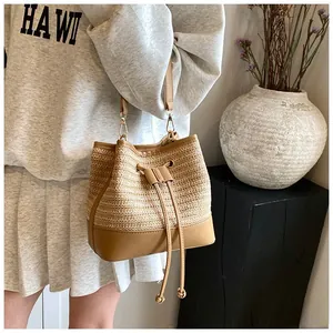 Detail of straw bucket bag with leather base and drawstring closure for summer