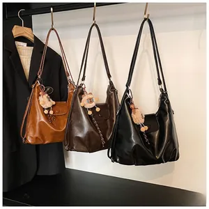 Detailed display of vintage faux leather shoulder bags in black, light and dark brown tones