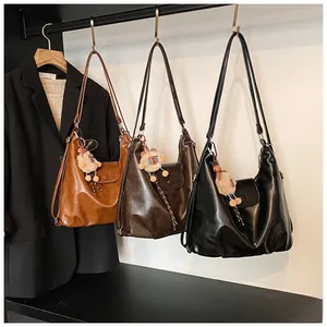 Three premium hobo shoulder bags in caramel, brown and black with plush animal charms