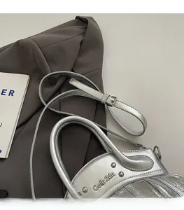 Detail of silver motorcycle bag with rivets, pleats, and sleek leather finish