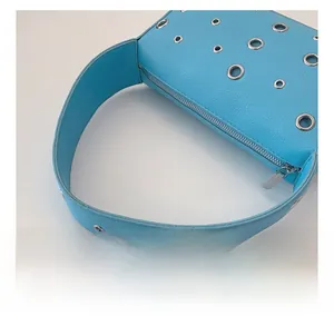 Detail of azure blue lychee leather bag featuring stylish silver metal eyelet grommets