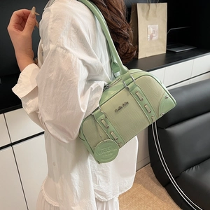 Light green Boston bag with wood grain texture and silver hardware on a female model