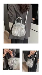 Detail showing silver pleated motorcycle bag with pearl charm and adjustable strap