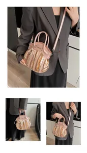 Detail of pink pleated motorcycle bag with pearl tassel and metallic gold texture accents