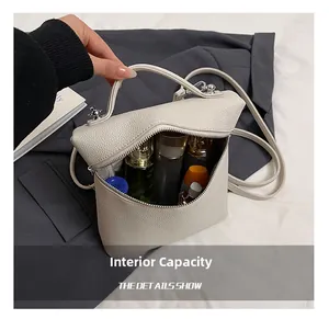 Detail shot of the cream-white pebbled leather handbag showing its internal storage capacity