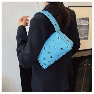 Detail of light blue underarm bag with silver metal eyelets and lychee leather texture