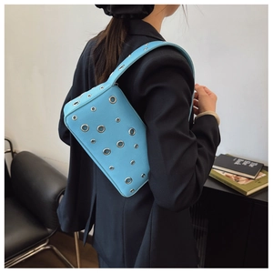 Close-up of light blue PU leather shoulder bag with metallic eyelets and wide strap