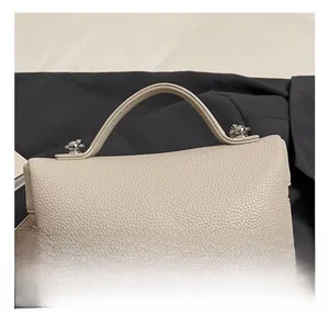 Close-up of litchi texture leather and silver metal buckles on a minimalist handbag